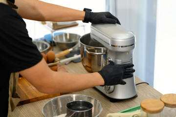 Cropped shot of young man mixing cookie dough with stand mixer