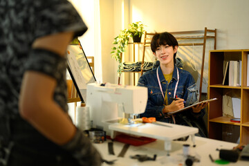 Two designers discussing ideas for a clothing project in a creative studio