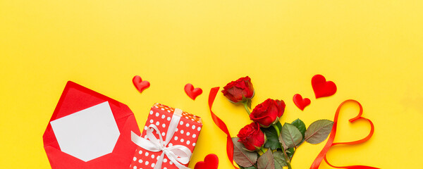 Valentine day composition with Envelope, rose flower and Red heart on table. Top view, flat lay. Holiday concept