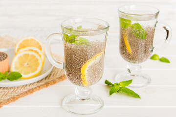 Healthy breakfast or morning with chia seeds lemon and mint on table background, vegetarian food, diet and health concept. Chia pudding with lemon and mint