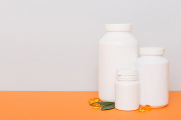 supplement pills with medicine bottle health care and medical top view. Vitamin tablets. Top view mockup bottle for pills and vitamins with green leaves, natural organic bio supplement, copy space