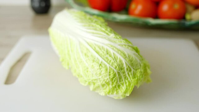 Close up of a chinese lettuce in a kitchen, healthy vegetable, green white, zoom out, for salad, copy space, more vegetables in the background, white wall behind