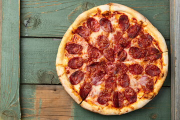 Pizza pepperoni fast food . Top view on rustic background