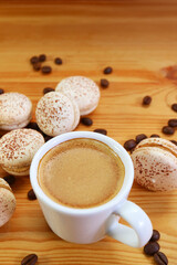 A Cup of Frothy Hot Espresso Coffee with Heap of Tiramisu Macarons Scattered Around