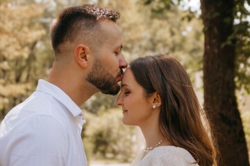 
the groom kisses the bride on the forehead