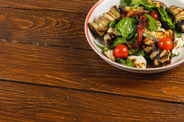 Colorful salad with grilled vegetables on a rustic wooden table