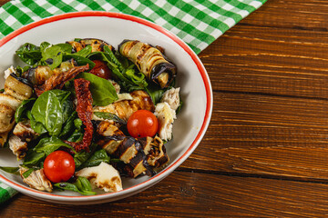 Grilled vegetable salad with spinach and cherry tomatoes on rustic table