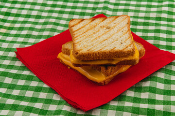 Delicious grilled cheese sandwich served on red napkin at casual brunch