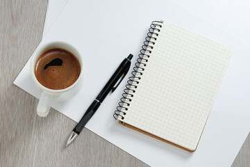Notebook with pen and cup of coffee