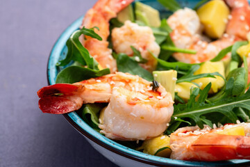 Salad with tiger shrimps , avocado and mango . Top view