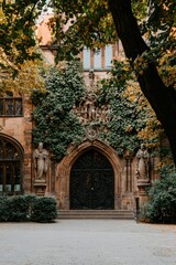 Fototapeta premium Ornate entry, building in autumn. Architectural detail. City scene with foliage