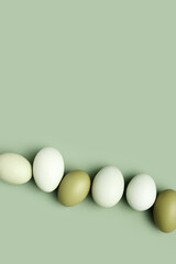 Top view natural easter Eggs green color with shadows on green background, minimal trend food pattern from organic Chicken egg with green gradient eggshells, Easter food celebration concept, copyspace