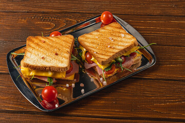 Grilled cheese with ham, spinach, and tomatoes served on a tray