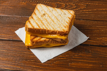 Delicious grilled cheese sandwich served on a wooden table for breakfast