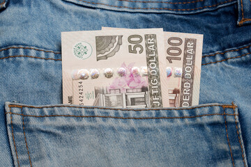 Surinamese dollarr in the pocket of blue jeans
