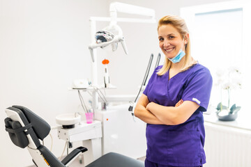 Fototapeta premium Portrait of happy dentist in her dentist's office. Confident adult woman working in a dental clinic.