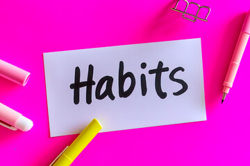 Fototapeta premium Habits note beside pens on pink background