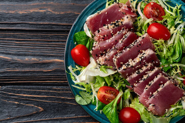Salad with raw tuna , sesame and cherry tomatoes photography . Top view