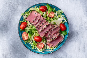 Salad with raw tuna , sesame and cherry tomatoes photography . Top view