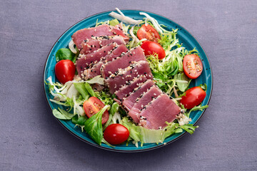Salad with raw tuna , sesame and cherry tomatoes photography . Top view