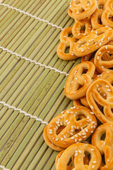 Crispy pretzels with sesame on a bamboo mat at a snack time gathering