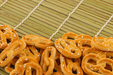 Savouring freshly baked pretzels with sesame seeds on a bamboo mat
