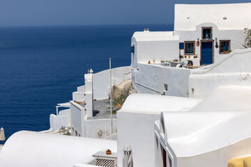 Obraz premium Whitewashed buildings on the edge of the caldera cliff in Oia village, Santorini, Greece