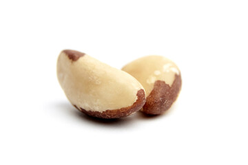 Two smooth Brazil nuts with natural brown skin patches and creamy textures, placed side by side on a clean white background