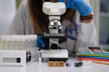 A dedicated scientist meticulously examines various samples under a powerful microscope in a modern...