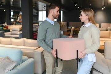 Happy couple choosing furniture in store