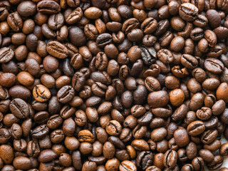 Background of scattered coffee beans, close-up view from above