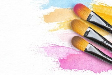Artistic arrangement of vibrant makeup brushes over colorful brush strokes on a blank canvas showcasing creativity