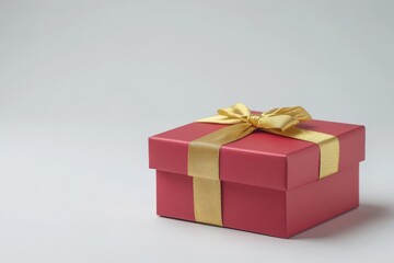 Obraz premium Red gift box with gold ribbon on plain background