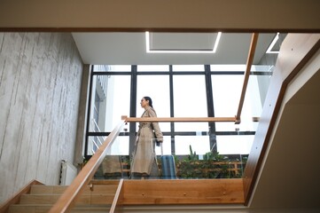 Beautiful businesswoman on stairs in modern hotel