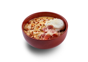 A bowl of creamy soup topped with a poached egg, crispy bacon, and a sprinkle of herbs.