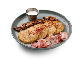 A hearty and delicious plate of potato pancakes (deruny), served with crispy bacon, sauteed...