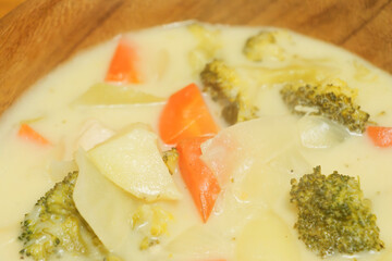 Warm stew with lots of vegetables, chicken and milk as ingredients
