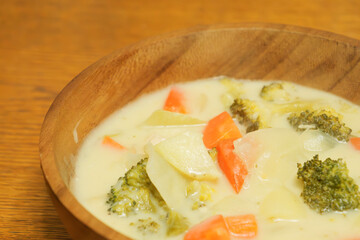 Warm stew with lots of vegetables, chicken and milk as ingredients