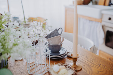 Fototapeta premium Vintage kitchen setting with stacked mugs and a flickering candle on table