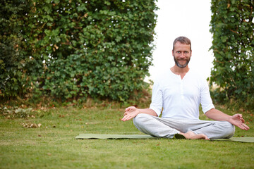 Yoga, meditation and portrait of man in garden for relax, wellness or peace for holistic fitness. Calm, yogi and happy mature person in easy pose on grass for zen, exercise or chakra for healthy body