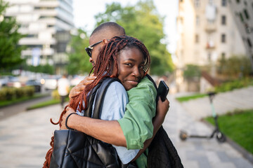 African American couple hugging tightly, woman holding onto man, sad farewell. Friends feel of longing and separation. Moving away for work or university, missing family, loved one go far abroad