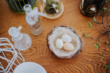 Vibrant Easter eggs placed in a decorative nest on a wooden table