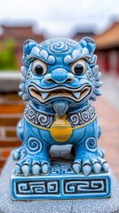 Obraz premium Intricately designed blue guardian lion statue with ornate patterns and golden medallion in traditional setting