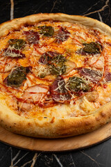 Pizza with ham, mozzarella cheese, bacon and basil