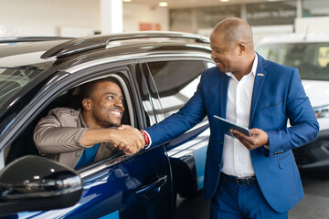 Car Seller Shaking Hands With Buyers After Successful Deal Selling Auto In Dealership Center....