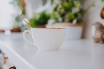 Cozy cup of warm beverage on a countertop surrounded by greenery