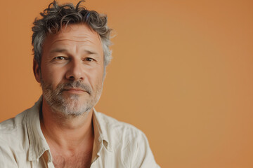 Obraz premium Portrait of a man isolated on a orange background. Adult, mature man, in a white shirt