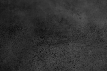 Smooth black surface with subtle texture in dim lighting atmosphere