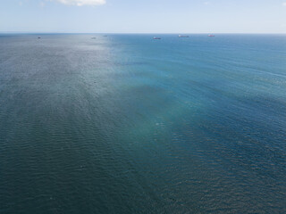 Aerial view of the ocean with cargo ships on the horizon and a visible halocline.