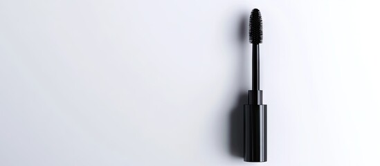 Naklejka premium Black mascara tube elegantly positioned on a pure white background showcasing its sleek design and glossy finish with natural light shadows.